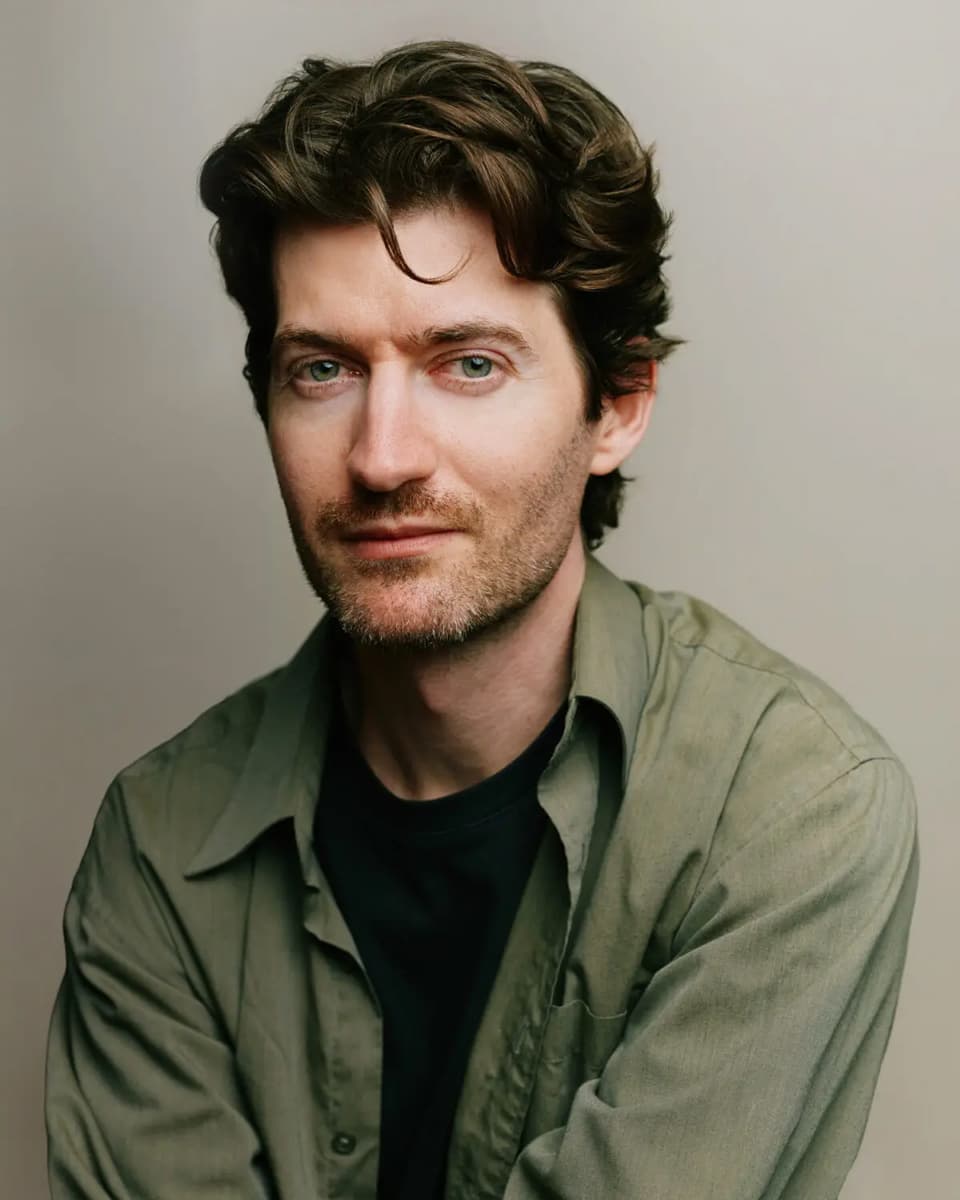 Calvin Thomas, Toronto headshot photographer and filmmaker, wearing an olive shirt and a relaxed smile against a soft grey background