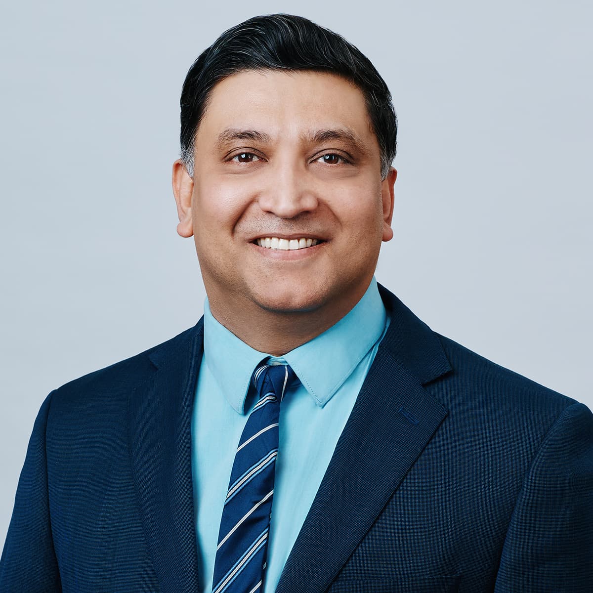 Executive headshot man navy suit clean backdrop